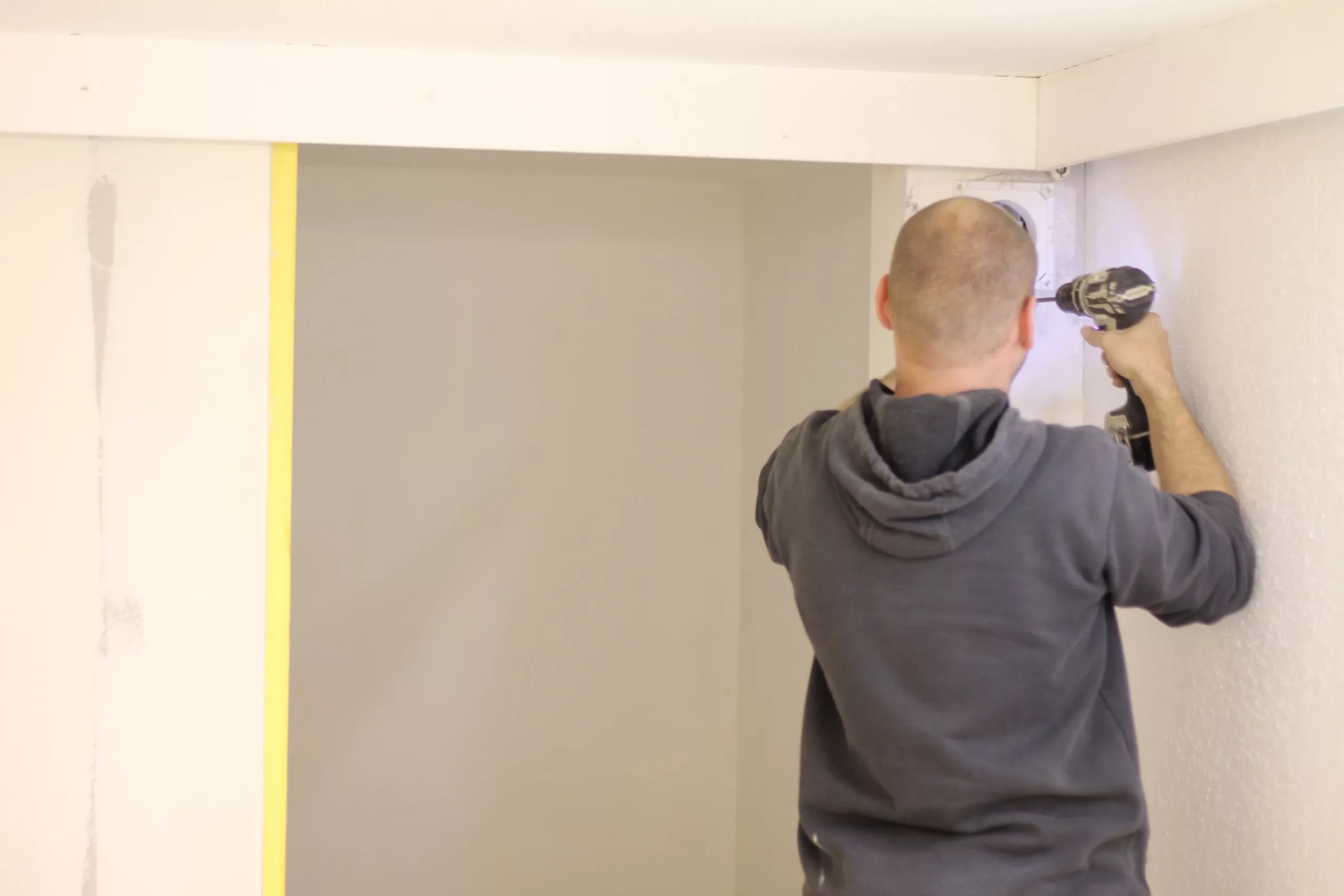 „Elektriker führt eine Bohr- und Installationsarbeit an einer Wand im Innenbereich durch.“